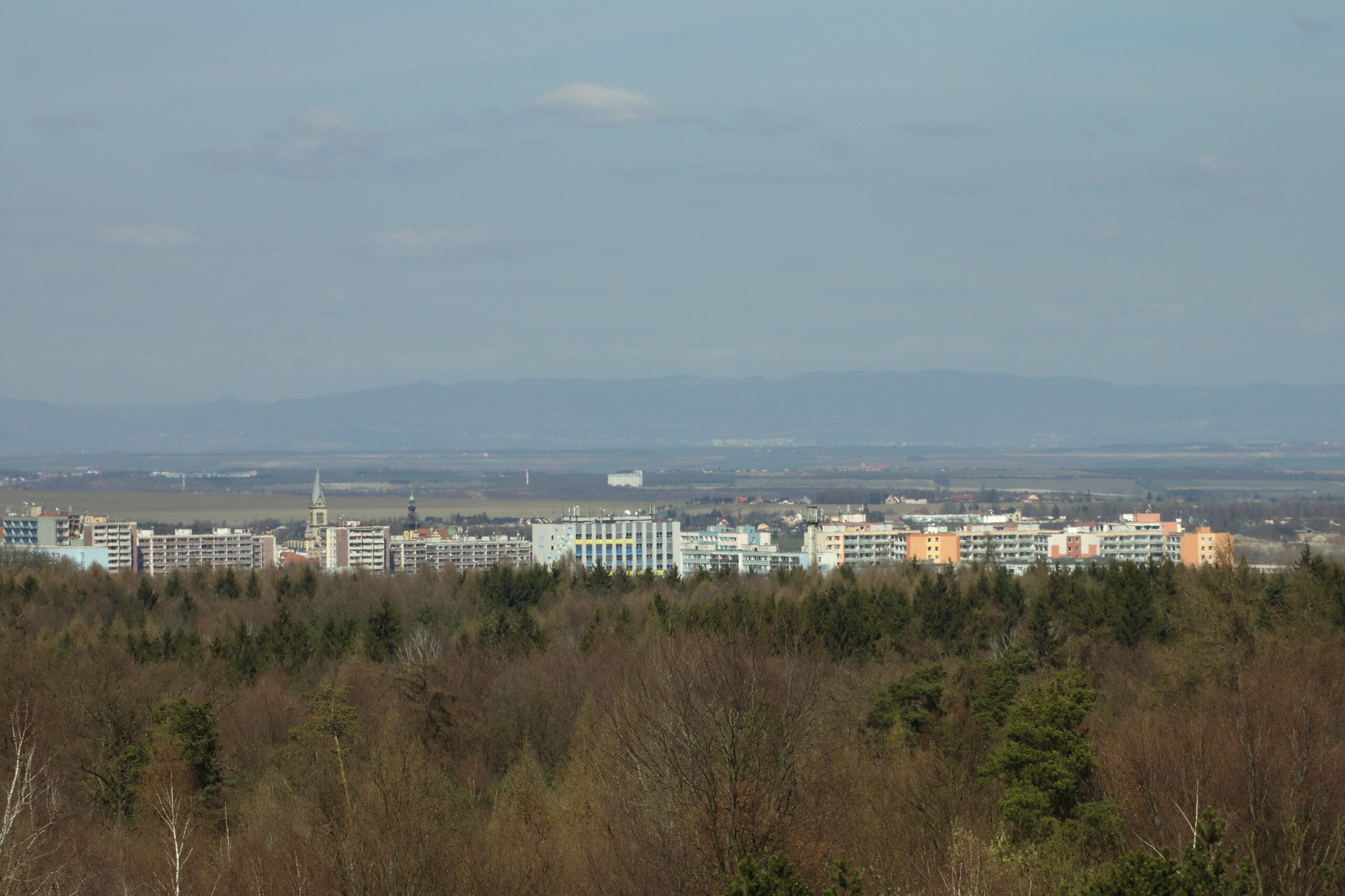 Panorama města Kladno z Kožové hory — pohled na střechy, věže kostela a okolní krajinu